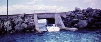 A power boat makes use of a culvert under the causeway in the low water years of the 1960’s.